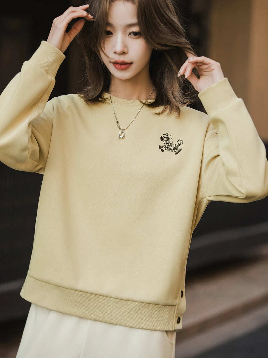 Dames sweatshirt geel met zebraborduursel en knopen aan de zijkant